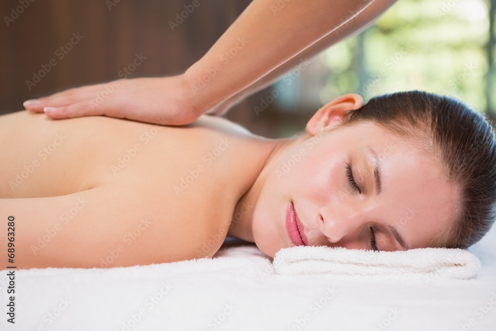 Attractive woman receiving back massage at spa center Attractive woman receiving back massage at spa center