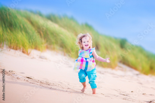 Little girl runnign in sand dunes