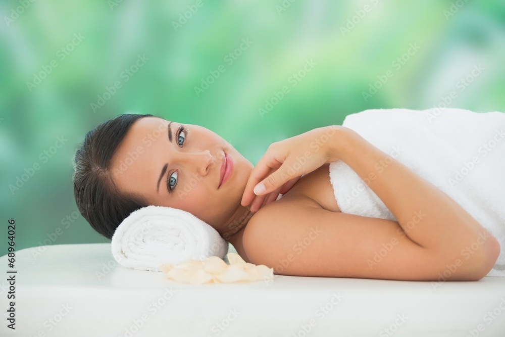 Obraz premium Beautiful brunette relaxing on massage table smiling at camera