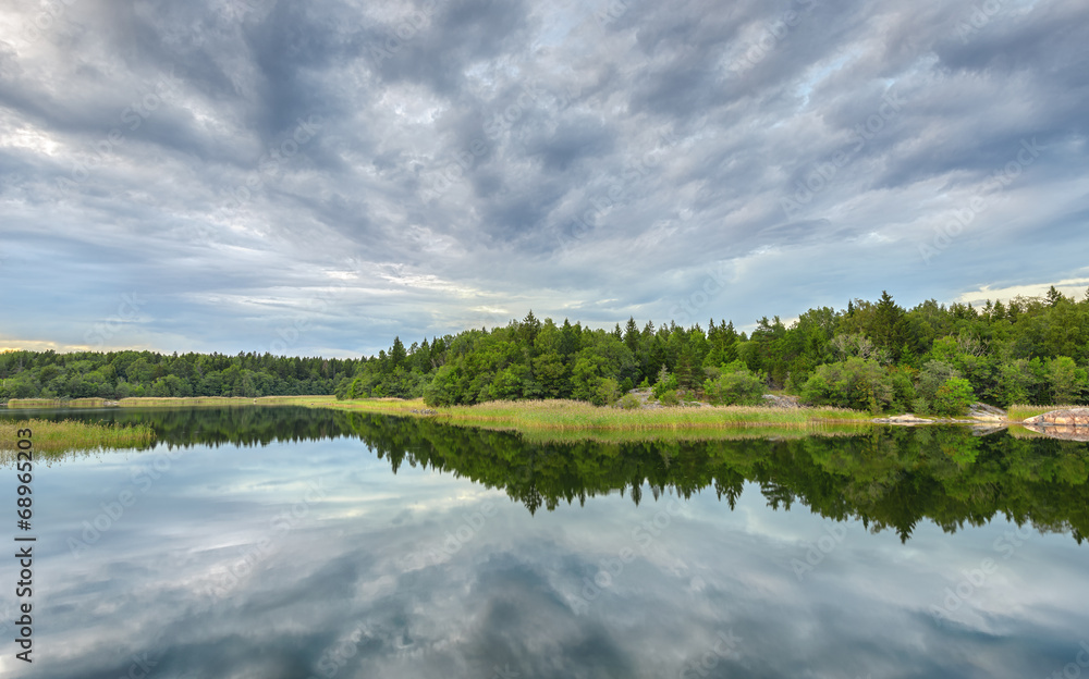 Forest and cloud reflections in lake
