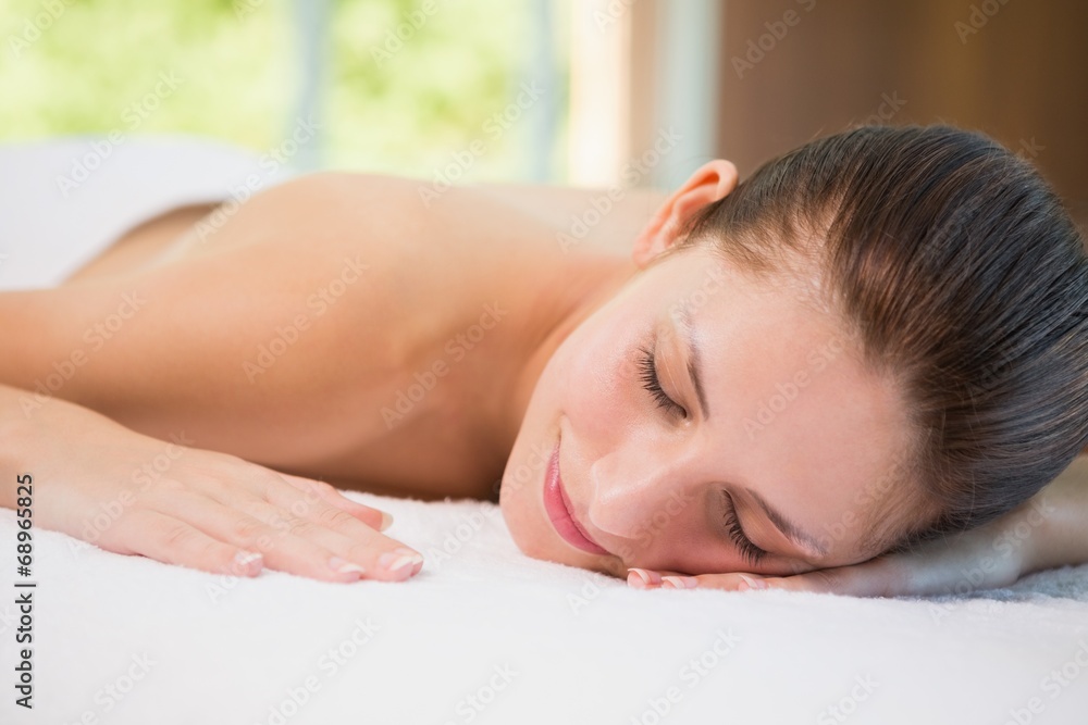 Beautiful woman lying on massage table at spa center Beautiful woman lying on massage table at spa center