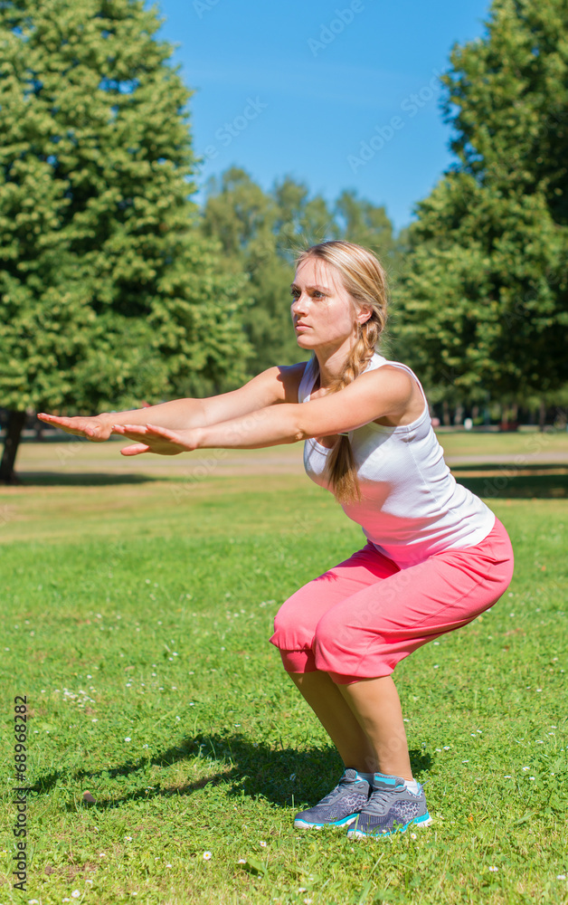 Fototapeta premium Young woman stretches before doing sports.