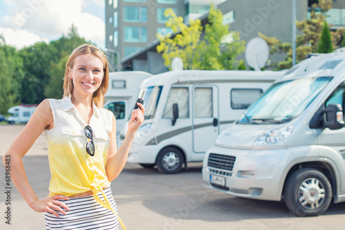 Beautiful young woman offers campervans at shop. photo