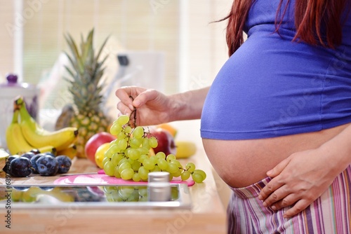 pragnant woman holding grapes photo