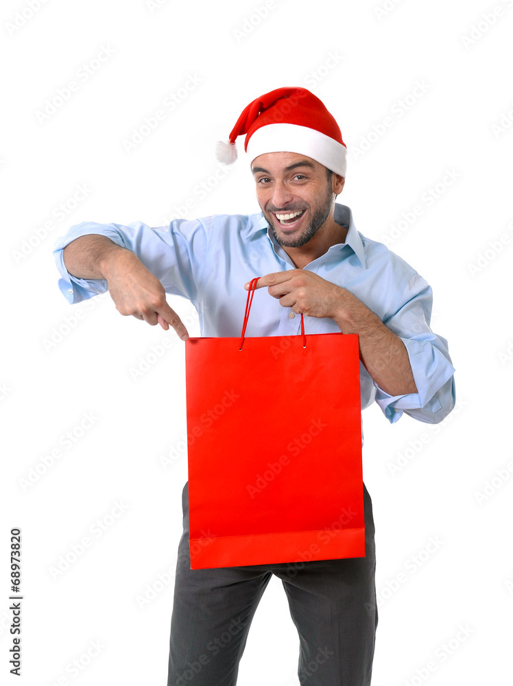 happy handsome man in santa hat pointing red shopping bag