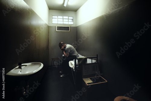 Fotografie One man on a bed of a small room of a prison