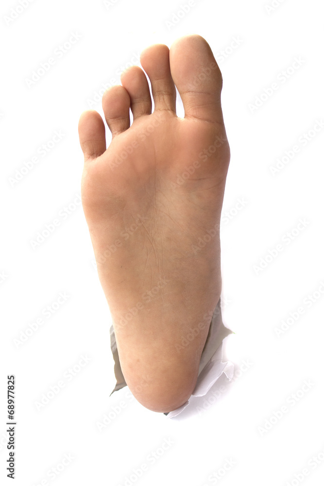 Foot with thumb up through a hole in paper Foot with thumb up through a hole in paper