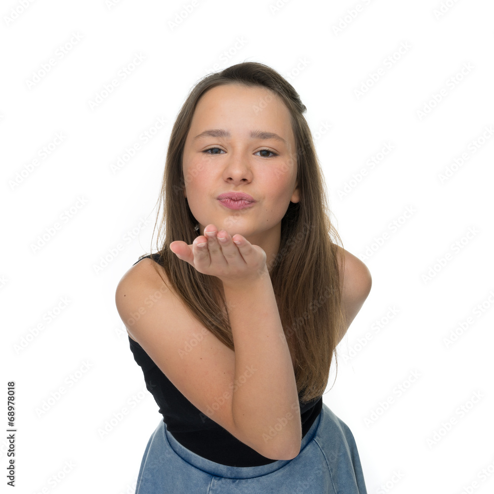 Fototapeta premium Playful young girl blowing a romantic kiss