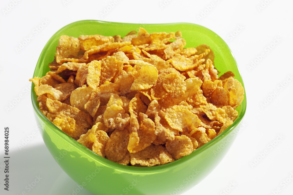 Cornflakes im grünen Glasschälchen auf weissem Untergrund Cornflakes im grünen Glasschälchen auf weissem Untergrund
