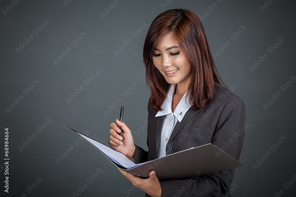 Asian businesswoman working with a pen and folder Asian businesswoman working with a pen and folder