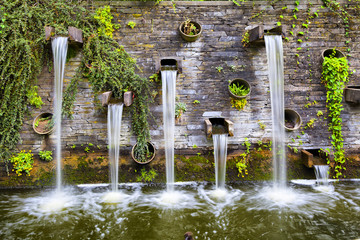 Fototapete Landschaften Felswand mit kleinen Wasserfällen im Park Planten un Blomen  © bbsferrari
