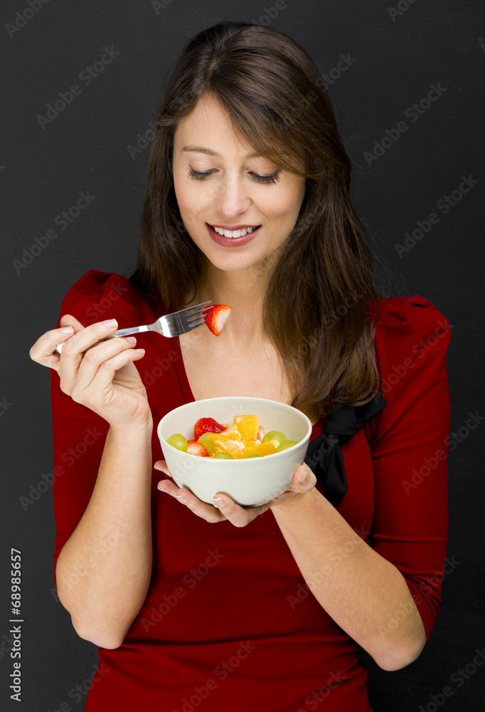 Woman eating a fruit salad