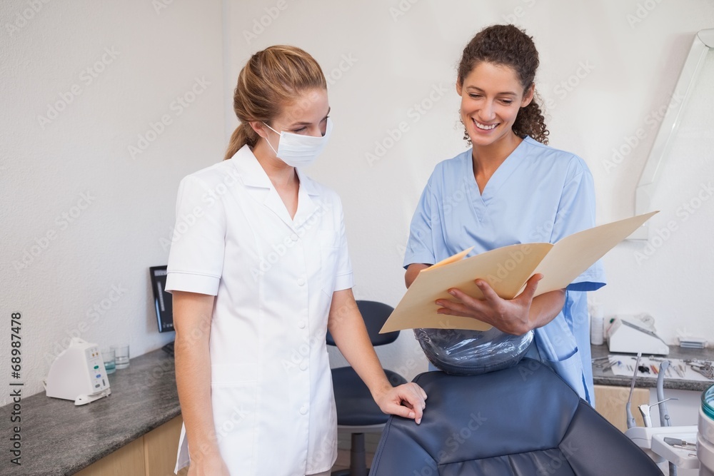 Obraz premium Dentist and assistant studying folders