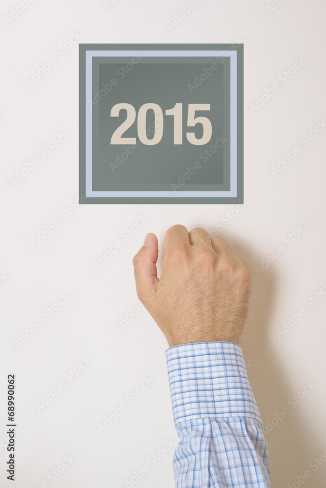 Businessman knocking on door with number 2015 Businessman knocking on door with number 2015