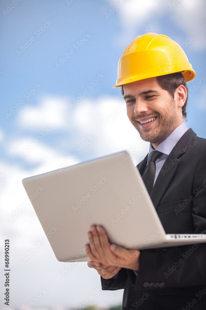handsome architect man holding laptop. handsome architect man holding laptop.