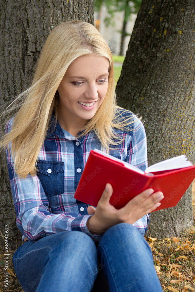 Obraz premium beautiful woman sitting in park and reading book