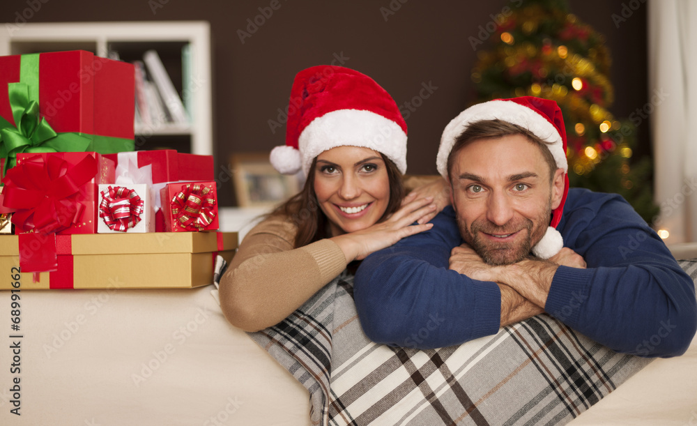 Portrait of happy couple in santa hat relaxing on sofa Portrait of happy couple in santa hat relaxing on sofa