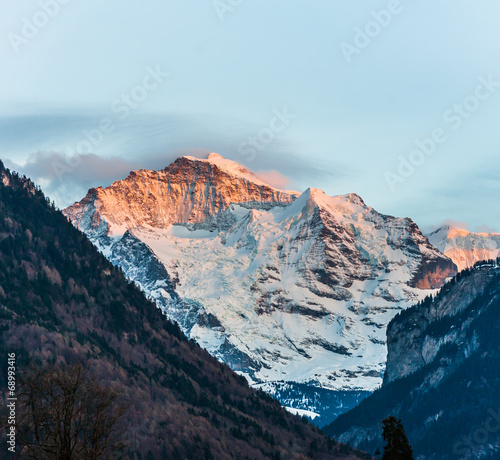 Top of ice mountain touching by sunlight