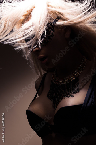 Beautiful, sexy blond woman in black underwear and mask