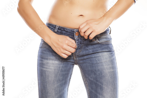 women zipping her jeans on white background © vladimirfloyd