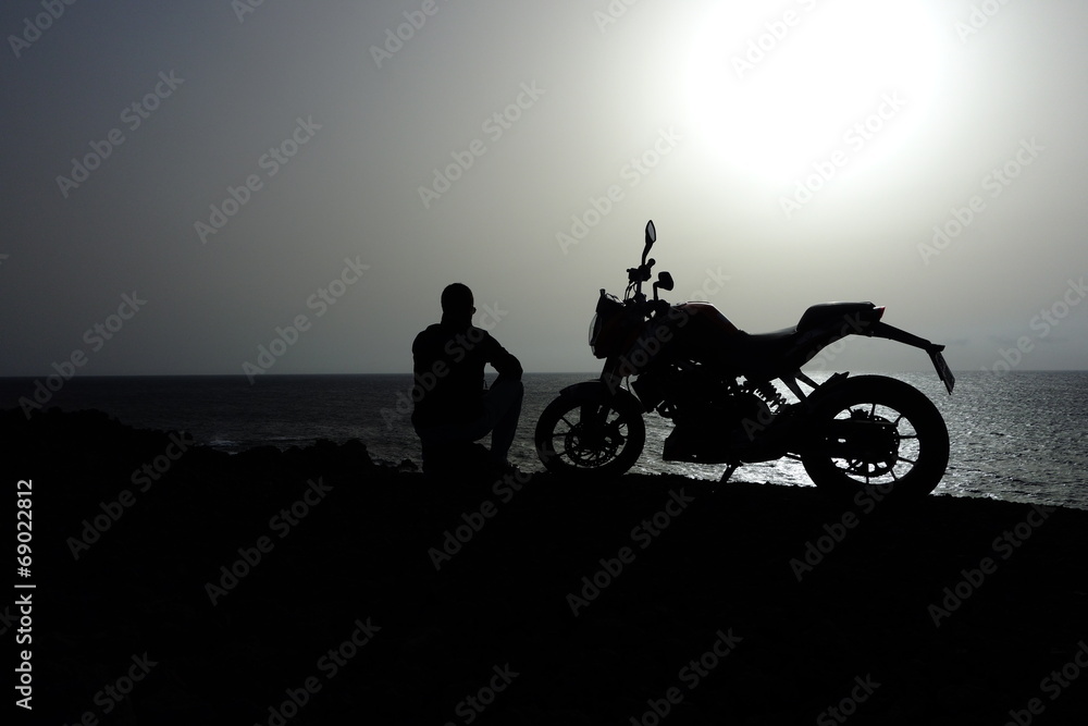 Fototapeta premium Hombre Sentado Junto A Su Motocicleta