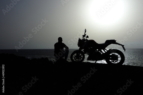 Hombre Sentado Junto A Su Motocicleta