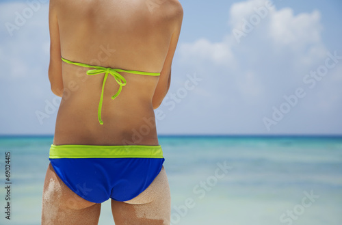 Young girl in bikini on the beach background
