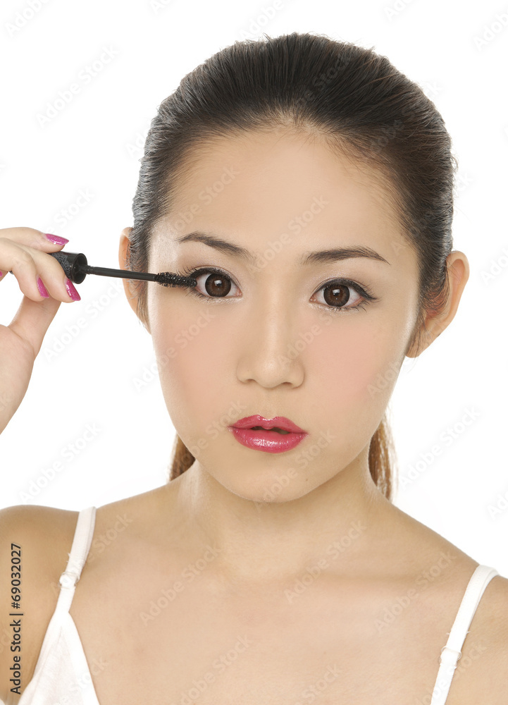 Young beautiful girl applying make-up. Close up.