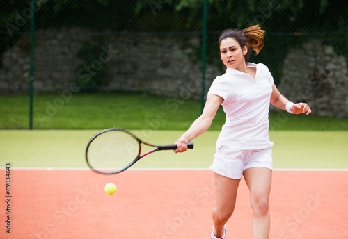 Pretty tennis player hitting ball