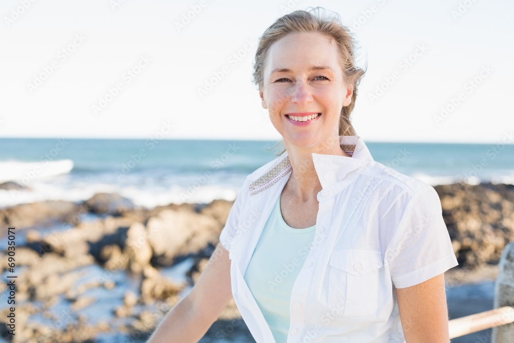 Casual woman smiling at camera by the sea Casual woman smiling at camera by the sea