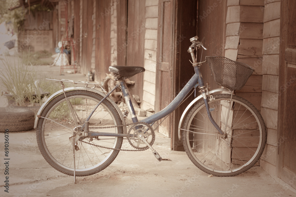 Old bike in front of the wooden wall at home