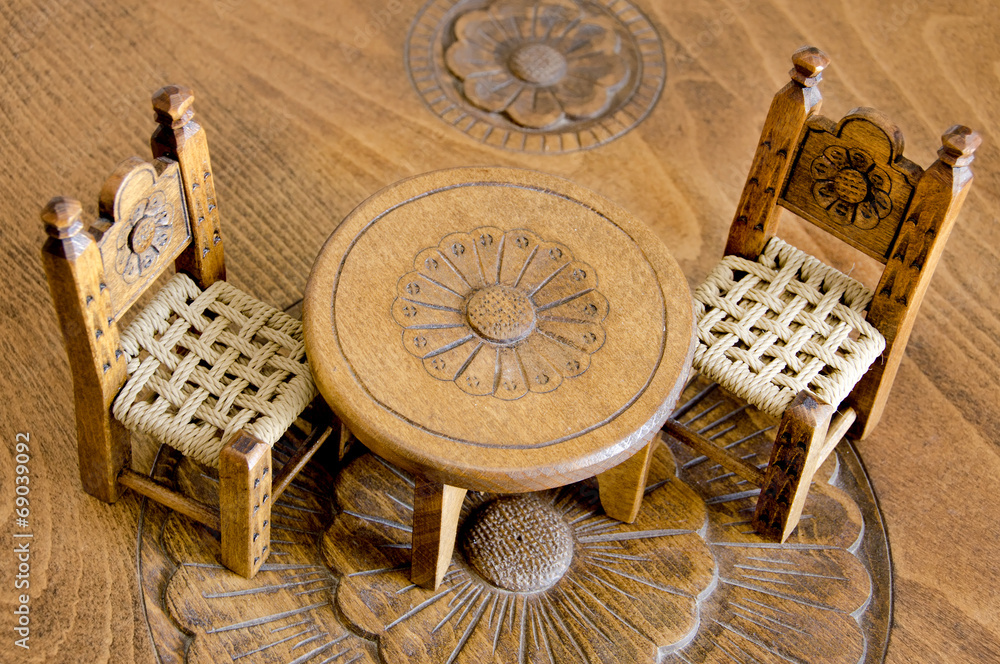 Mini wooden hand made chairs and table on carved table