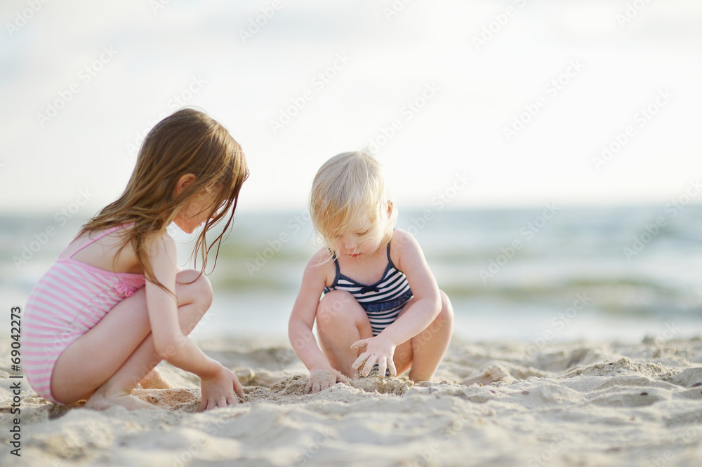 Two little sisters having fun on a beach Two little sisters having fun on a beach