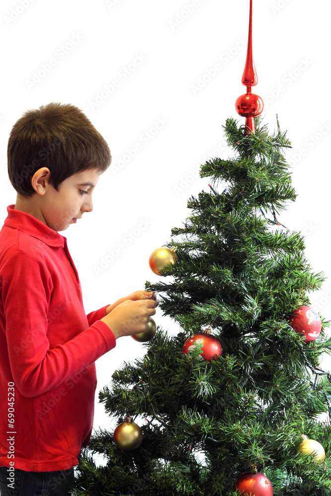 Young boy decorating a Christmas tree Young boy decorating a Christmas tree