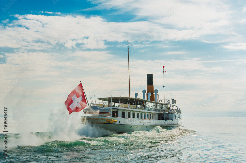 Fototapeta premium Steam boat with swiss flag floating on the lake Geneva
