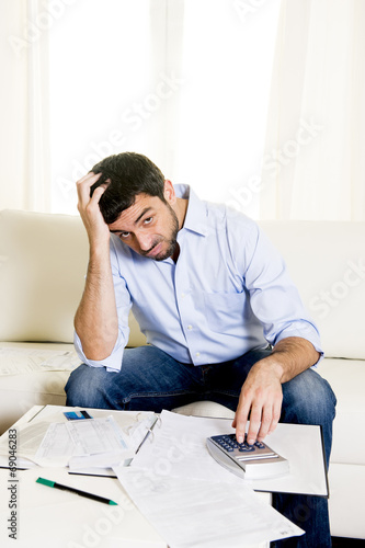 latin business man worried paying bills on couch