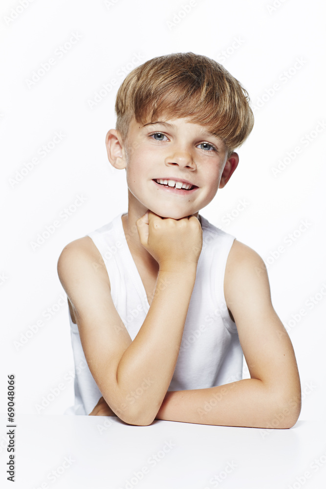 Portrait of young boy in vest, studio.