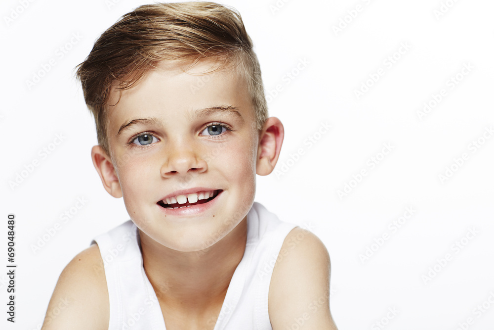 Portrait of young boy in vest, smiling.