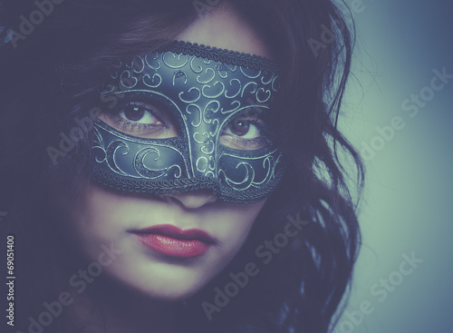 Beautiful young woman wearing Venetian mask