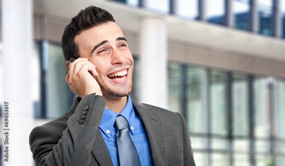 Smiling young manager talking on the phone Smiling young manager talking on the phone