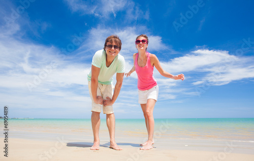 front view of happy young couple at tropical beach