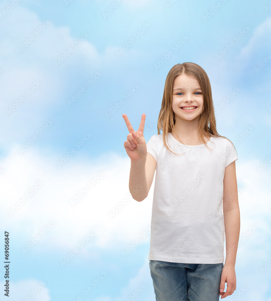 little girl in white t-shirt showing peace gesture little girl in white t-shirt showing peace gesture