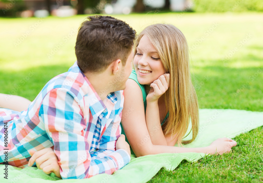 smiling couple lying on blanket in park smiling couple lying on blanket in park