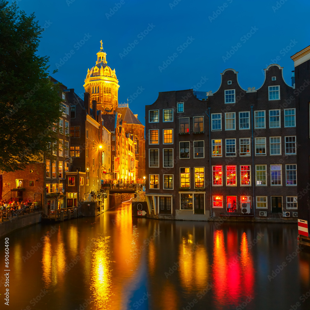 Night city view of Amsterdam canal, church and bridge
