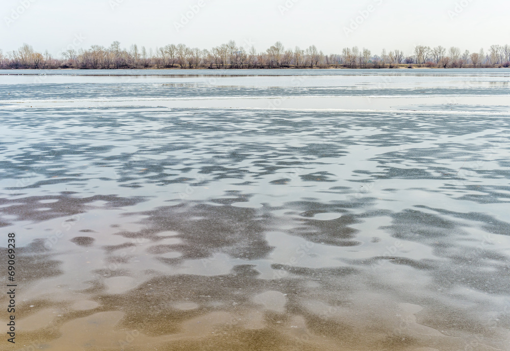 Icy Dnieper River with  gray reflections during a sad and cold winter day