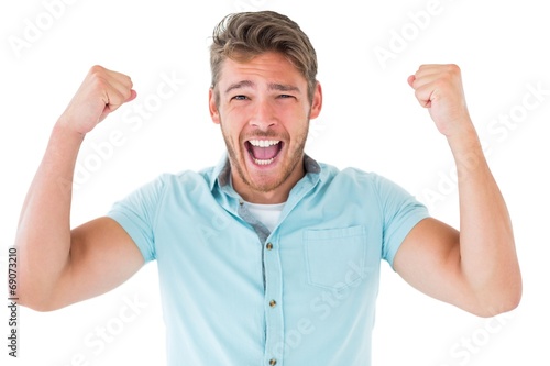 Handsome young man cheering at camera