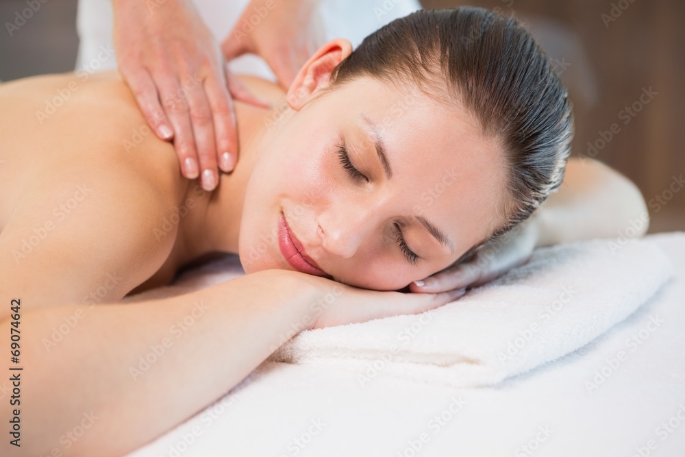 Attractive woman receiving back massage at spa center Attractive woman receiving back massage at spa center