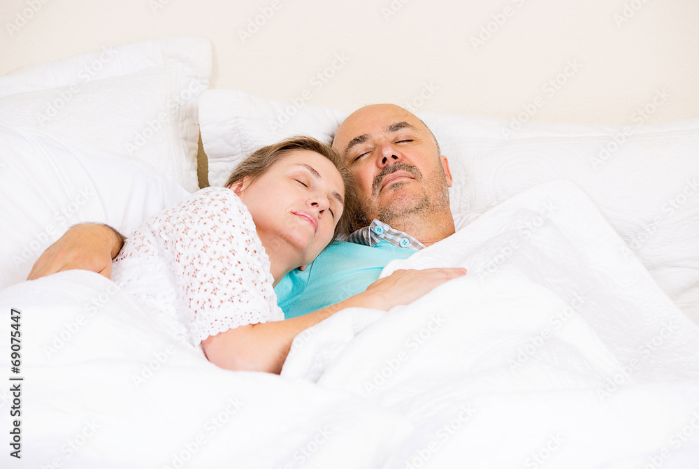 Happy mature middle aged couple relaxing, sleeping in a bed Happy mature middle aged couple relaxing, sleeping in a bed