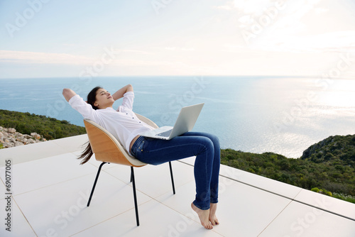 relaxed young woman at home working on laptop