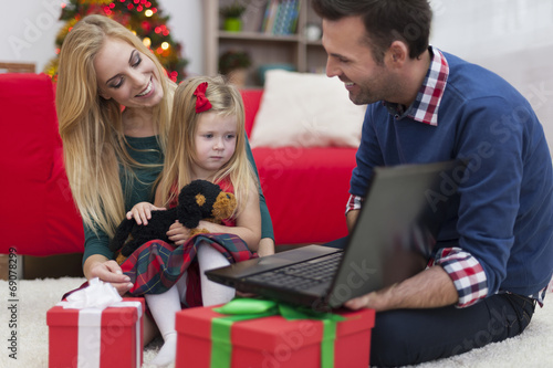 Little girl with parents using laptop in Christmas